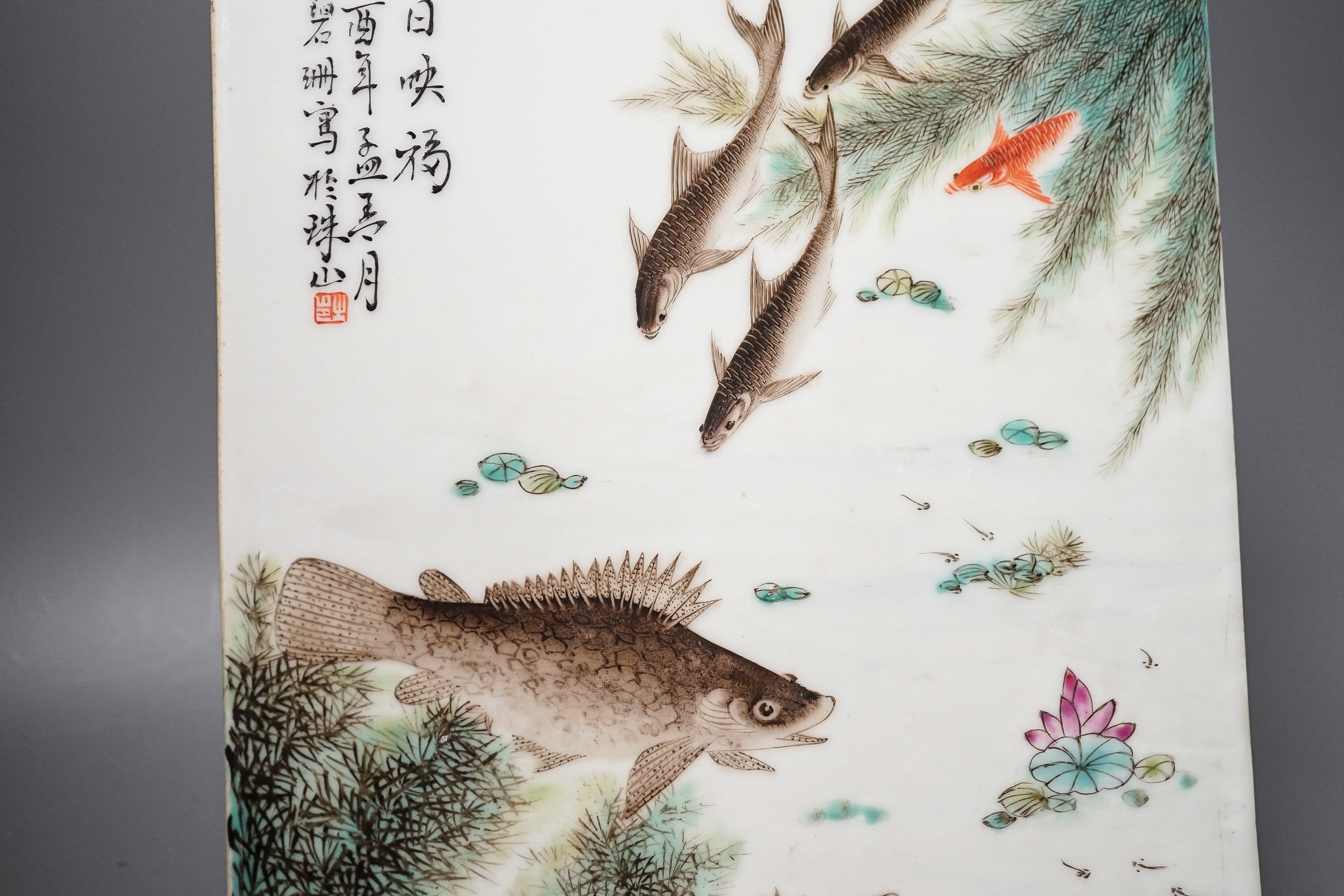 A Chinese famille rose porcelain rectangular plaque, Republic period (1912-49), painted with fish in a pond amid weed and inscribed upper left 36.5x25.5cm